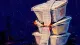 Stacked Silence Three takeout containers are cinched into a leaning stack by a tight receipt strip, suggesting the B