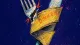 Dinner Under Review A split cutlery sleeve gripping a fork and knife, symbolizing the pressure to sound accomplished ata