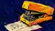 The Stalled Proof A warped stapler jammed over a status note, representing compulsive work used to avoid an unanswered