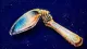A teaspoon bent back and forth until its neck folds against the handle, symbolising paralysis