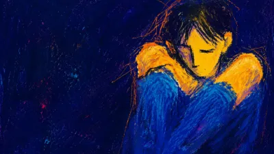 A solitary figure with raised shoulders and a braced torso, warm amber ending sharply against cool indigo space.