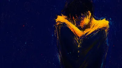 A solitary figure with raised shoulders in dark space, warm amber ending at dim torso edges against cold indigo.