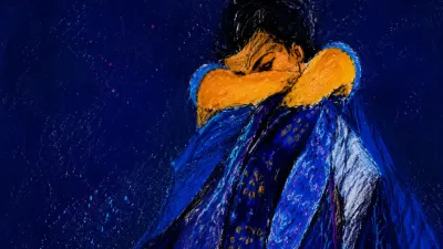 A solitary figure with raised shoulders, layered blue fabric and a patterned veil, amber suspended against deep indigo