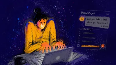 A figure with both hands over a laptop keyboard, shoulders lifted, amber light narrowing across a cool grey workspace.